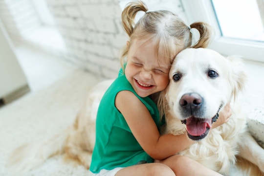 Bambino sorridente che abbraccia un cane felice.